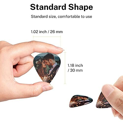 Hands holding and showing a standard shape guitar pick with a couple's photo